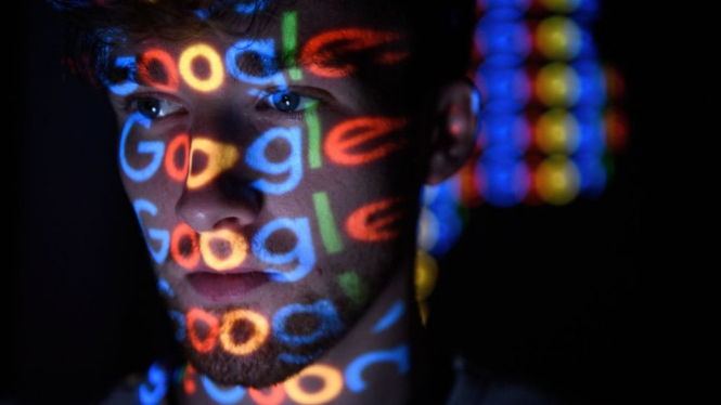 Seorang anak memandang layar dengan tampilan logo Google. -Getty Images