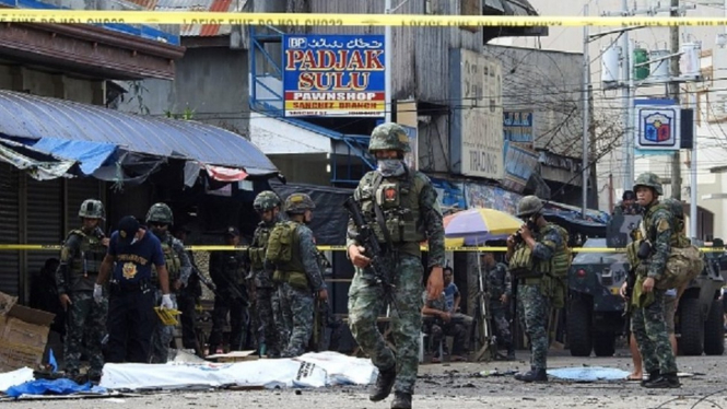 Aparat keamanan Filipina mengamankan lokasi ledakan bom bunuh diri di Gereja Katolik. - NICKEE BUTLANGAN/AFP/Getty Images