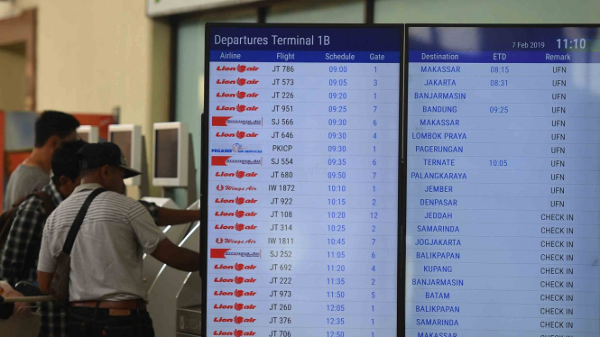 Sejumlah calon penumpang mencetak tiket di samping layar informasi penerbangan di terminal keberangkatan domestik 1B Bandara Internasional  Juanda Surabaya, Sidoarjo, Jawa Timur, Kamis, 7 Februari 2019.