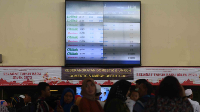 Calon penumpang mengamati layar informasi penerbangan di terminal keberangkatan domestik 1A Bandara Internasional  Juanda Surabaya, Sidoarjo, Jawa Timur, Kamis, 7 Februari 2019.