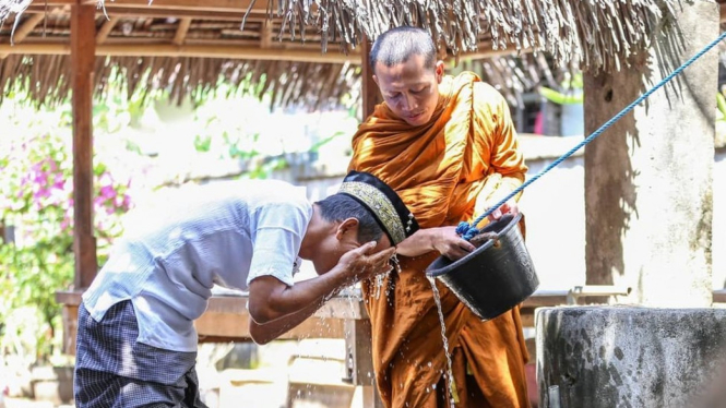 Foto seorang biksu yang sedang membantu seorang pria berwudu menjadi viral di media sosial. - Ivan Mardiansyah