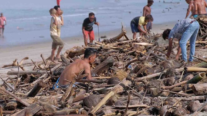 Turistas internacionales ayudan a limpiar la basura arrastrada por el mal tiempo en la playa de Kuta, Badung, Bali, el lunes 11 de febrero de 2019.