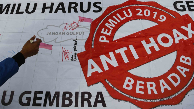 Seorang warga membubuhkan tanda tangan untuk mendukung Pemilu 2019 anti hoax saat berlangsung Hari Bebas Kendaraan Bermotor (HBKB) di Kawasan Bundaran HI Jakarta