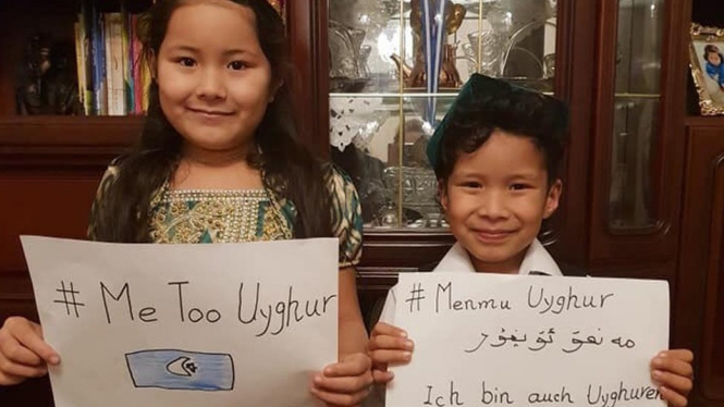 Dua anak mengusung poster bertuliskan #MeTooUyghur. - Halmurat Harri
