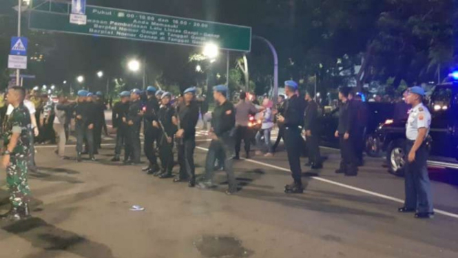 Polisi dan Pasukan Pengamanan Presiden bersiaga setelah massa pengunjuk rasa sempat menerobos konvoi mobil Presiden Joko Widodo melintas di Jalan Medan Merdeka Barat, Gambir, Jakarta, Rabu malam, 13 Februari 2019.