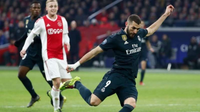 Penyerang Real Madrid, Karim Benzema, mencetak gol ke gawang Ajax Amsterdam