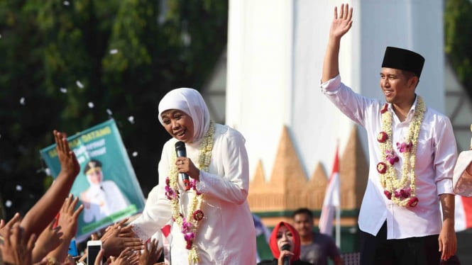 Gubernur Jawa Timur Khofifah Indar Parawansa (kiri) bersama Wakil Gubernur Jawa Timur Emil Elestianto Dardak (kanan) menyapa warga ketika tiba di kawasan Tugu Pahlawan, Surabaya, Jawa Timur