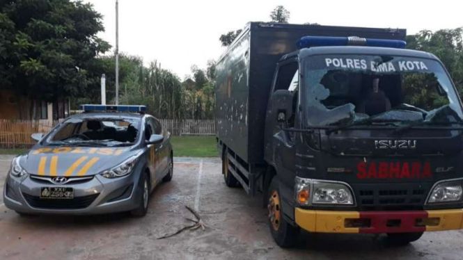 Dua mobil polisi dirusak massa saat terjadi bentrokan di Bima, 16 Februari 2019.