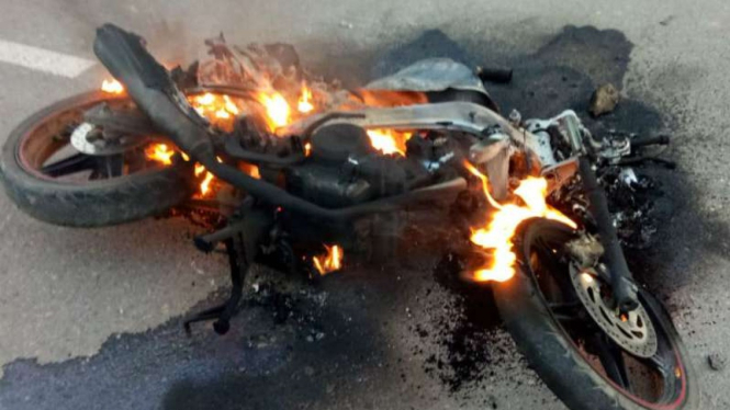 Sebuah motor dibakar dalam bentrokan massa di Bima, NTB, 16 Februari 2019.