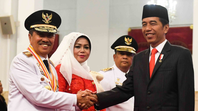 Presiden Joko Widodo (kanan) berjabat tangan dengan Gubernur Riau yang baru dilantik Syamsuar (kiri) dan Wakil Gubernur Riau Edi Natar Nasution (ketiga kiri) di Istana Negara, Jakarta, 20 Februari 2019.