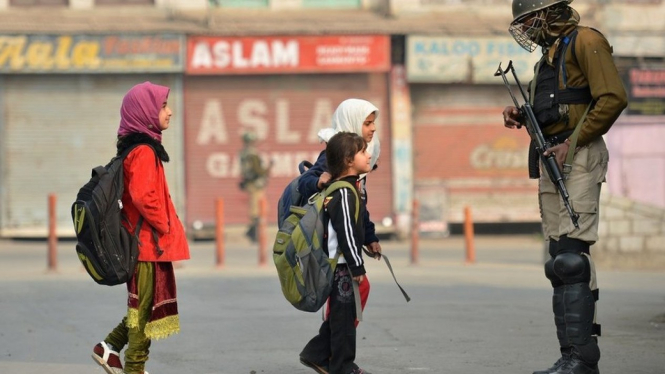 Anak sekolah Kashmir melewati paramiliter India.-Getty Images