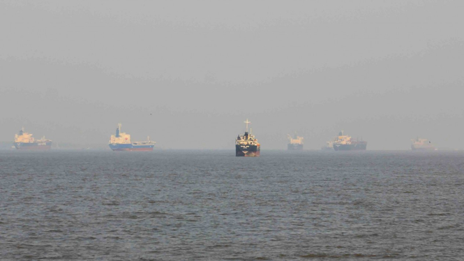 Sejumlah kapal tanker berlabuh di sekitar perairan Pulau Rupat yang berkabut asap dari kebakaran hutan dan lahan (karhutla) di kecamatan Rupat Selatan, kabupaten Bengkalis, Riau