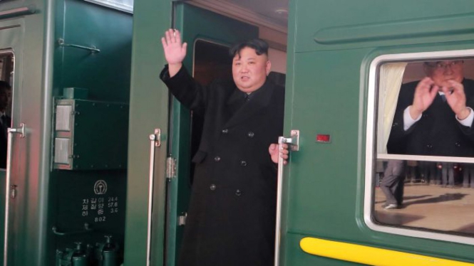 Pemimpin Korea Utara Kim Jong-un melambaikan tangan dari kereta yang akan membawanya ke perbatasan China-Vietnam guna menghadiri KTT dengan Presiden Trump hari Kamis.