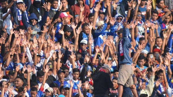 Aksi Aremania saat memberi dukungan di stadion beberapa waktu lalu. 