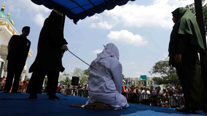 Terpidana kasus pelanggar peraturan daerah (qanun) tentang Syariat Islam dieksekusi cambuk oleh algojo di halaman masjid Syuhada, Banda Aceh, Aceh