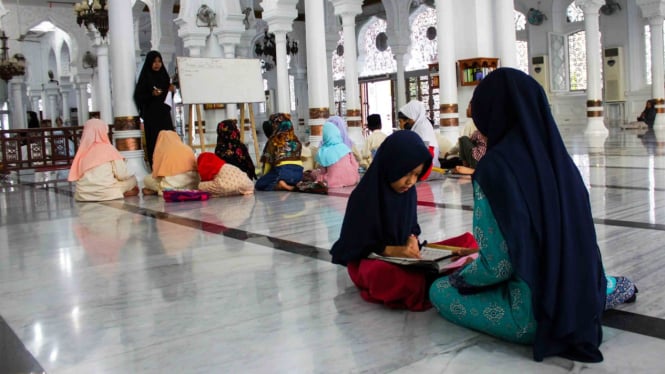 Ustajah mengajar santri mengaji dan pendidikan agama di Masjid Raya Baiturrahman, Banda Aceh