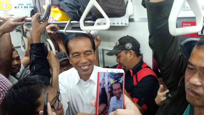 Presiden Joko Widodo (tengah) saat menaiki kereta listrik atau KRL di Jakarta, 6 Maret 2019.