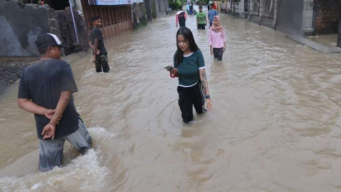 Sejumlah warga melewati banjir yang merendam perkampungan warga di Cawas Klaten