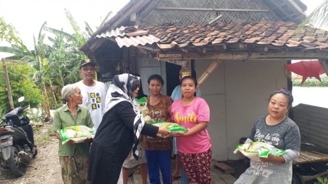 Hj Yuniwati saat menyerahkan paket beras kepada warga miskin di Desa Sentul, Kecamatan Tanggulangi, Sidoarjo