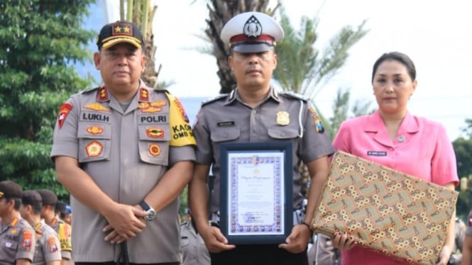 Aiptu Sujadi (tengah), anggota Polres Kediri yang menyelamatkan balita korban banjir, menerima penghargaan dari Kepala Polda Jawa Timur Irjen Pol Luki Hermawan di Surabaya pada Senin, 11 Maret 2019.