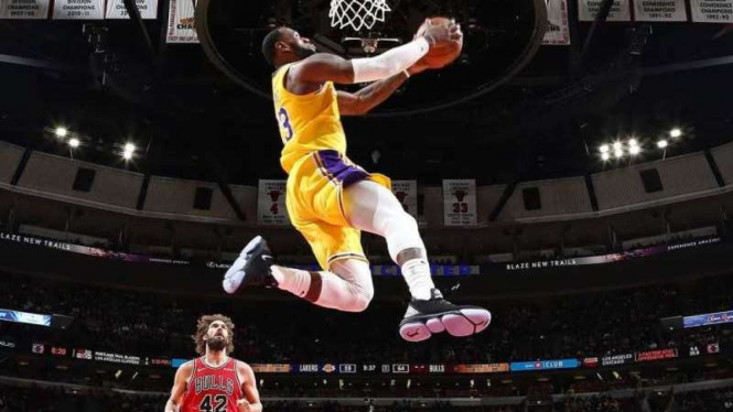 Bintang Los Angeles Lakers, LeBron James, melakukan aksi slam dunk