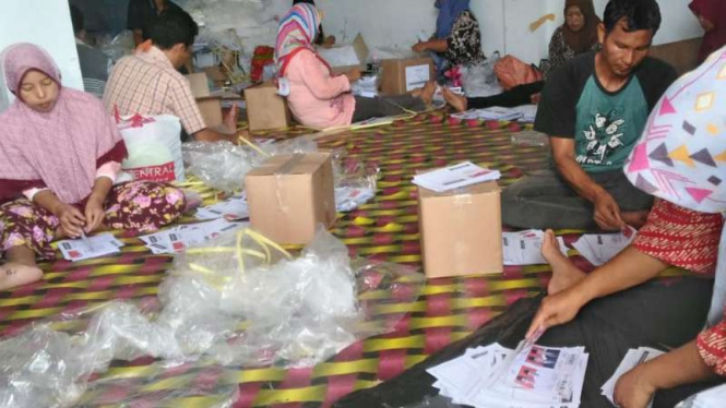 Ibu-ibu merapikan surat suara di Jambi.