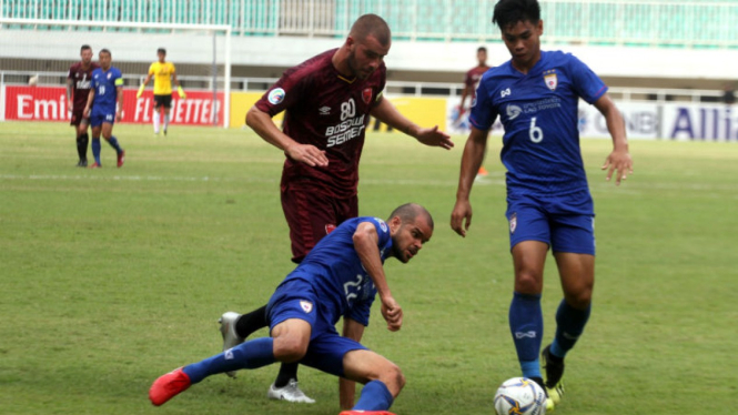 Gelandang PSM Makassar, Willem Jan Pluim, saat berebut bola dengan pemain Lao