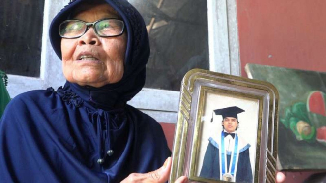 Yusni (71) ibu dari Zulfirman Syah tengah memperlihatkan foto korban.