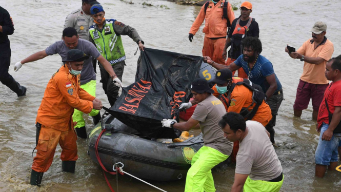 Tim SAR Gabungan mengangkat kantong mayat jenazah korban banjir bandang Sentani yang di temukan di sekitar perumahan Gajah Mada di  Sentani, Jaya Pura, Papua, Selasa, 19 Maret 2019.