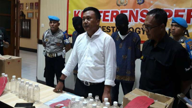 Polisi memperlihatkan dua orang penjual minuman keras jenis ciu yang menewaskan enam orang di Yogyakarta, Selasa, 19 Maret 2019.