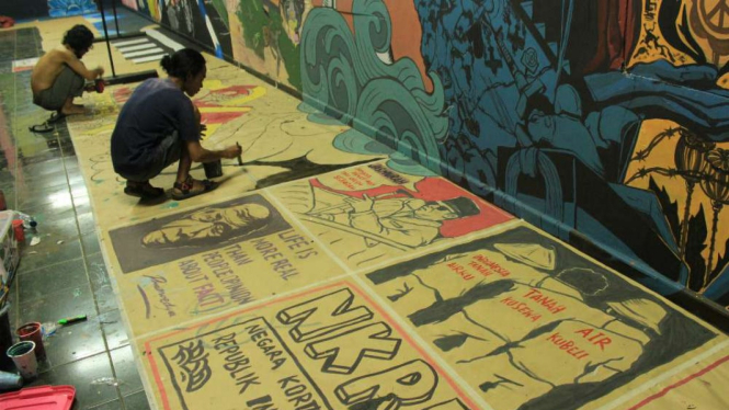 Pekerja seni sedang membuat mural di Bengkulu.