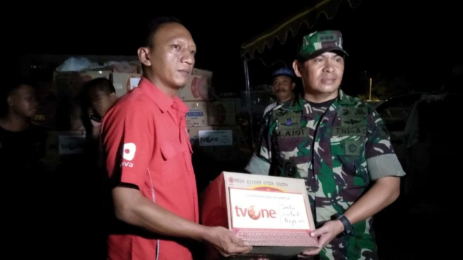 Budi Mulyono (kiri), staf Yayasan Satu untuk Negeri, menyerahkan bantuan pemirsa tvOne untuk para korban banjir bandang melalui Kapendam 17/Cendrawasih Kolonel Infanteri M Aidi di Sentani, Jayapura, Selasa, 19 Maret 2019.