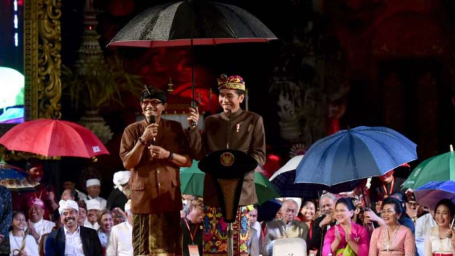 Hujan deras saat acara, jokowi payungi seorang tokoh adat di Bali, 22 Maret 2019