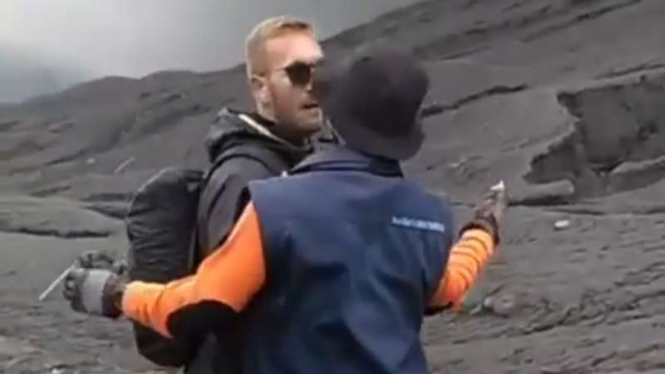 Potongan gambar rekaman video aparat menghalangi seorang turis asing yang hendak menerobos ke kawah Gunung Bromo yang sedang erupsi Jumat siang, 22 Maret 2019.