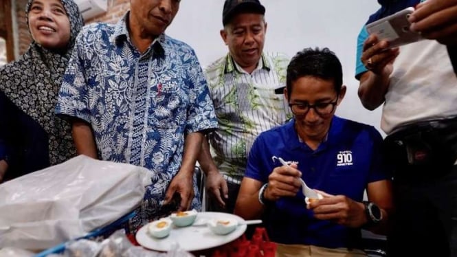 Cawapres Sandiaga Uno saat mencicipi telur asin bersama warga setempat.