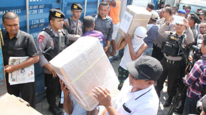 Polisi bersenjata lengkap mengawasi pembongkaran peti kemas-peti kemas bermuatan logistik surat suara pemilu di Pelabuhan Ahmad Yani, Ternate, Maluku Utara, Senin, 25 Maret 2019.