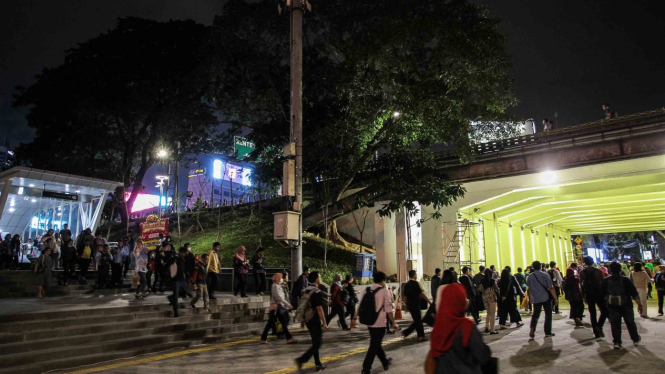 Warga berjalan melewati terowongan jalur pedestrian yang dihiasi lampu warna-warni di Jalan Kendal, dekat Stasiun Sudirman, kawasan Dukuh Atas, Jakarta Pusat, Selasa, 26 Maret 2019.
