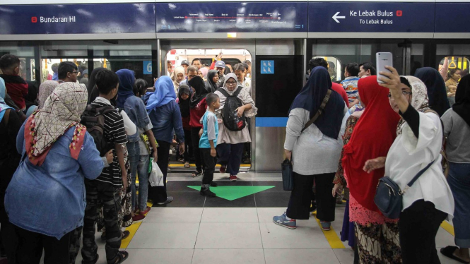 Warga antre untuk menaiki kereta MRT pada hari terakhir periode gratis di Stasiun MRT Bundaran HI, Jakarta