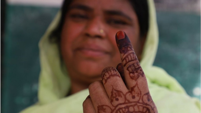 Seorang perempuan menunjukkan tinta pada jarinya seusai memberikan suaranya di luar sebuah TPS di negara bagian Uttar Pradesh, India, Kamis (11/4). - NurPhoto/Getty Images