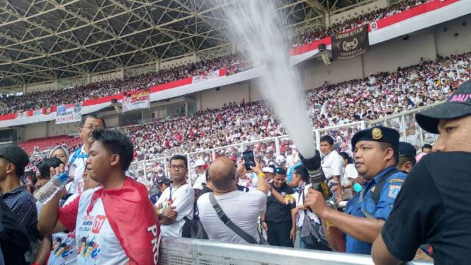 Petugas menyemprotkan air dalam kampanye akbar Jokowi di GBK, Jakarta.