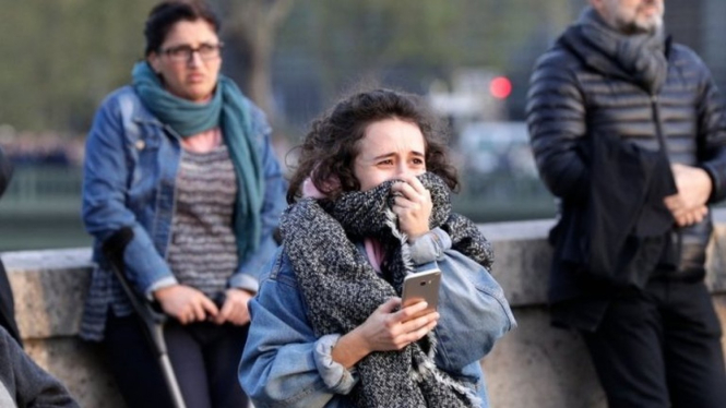 Seorang perempuan terisak menyaksikan Notre Dame terbakar di depan matanya - AFP