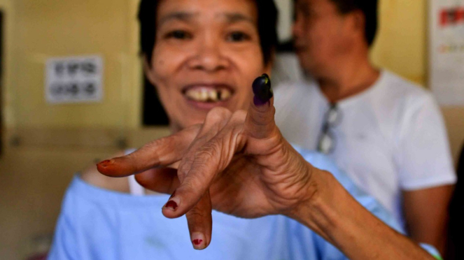 Salah seorang penyandang disabilitas kejiwaan memperlihatkan tinta di jarinya usai memilih di TPS 022, Rumah Sakit Jiwa (RSJ) Ratumbuysang, Manado, Sulawesi Utara