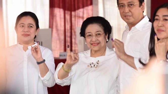 Ketua Umum PDI Perjuangan yang juga Presiden kelima RI Megawati Soekarnoputri (tengah) bersama putrinya Puan Maharani (kiri) dan putranya Muhammad Prananda Prabowo (kedua kanan) menunjukkan jarinya yang telah dicelup tinta seusai menggunakan hak pilihnya 