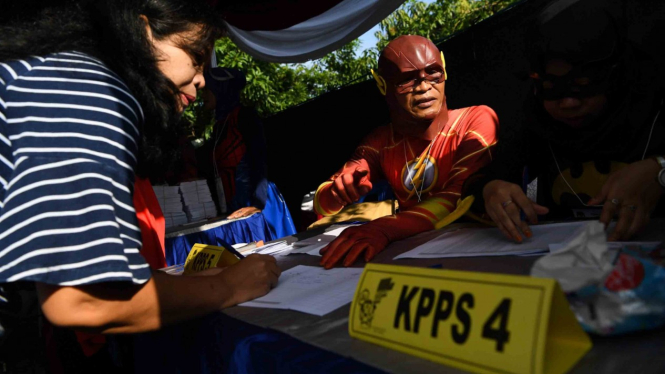Petugas KPPS melayani warga saat akan memberikan hak suaranya di TPS 5 Pondok Benowo Indah yang bertema super hero di Surabaya, Jawa Timur, Rabu, 17 April 2019.