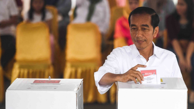 Calon Presiden petahana Joko Widodo memasukkan surat suara ke dalam kotak saat menggunakan hak pilihnya di TPS 008, Gambir, Jakarta.