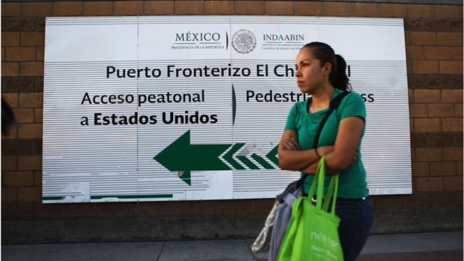 Seorang perempuan berdiri dekat pos perbatasan Amerika Serikat di Tijuana, Meksiko. - Getty Images