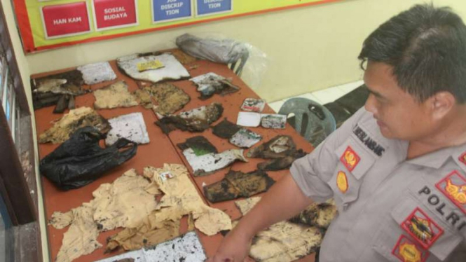Polisi memperlihatkan barang bukti sejumlah surat suara pemilu bekas terbakar di gudang logistik KPU Kabupaten Pesisir Selatan, Sumatera Barat, Senin, 22 April 2019.
