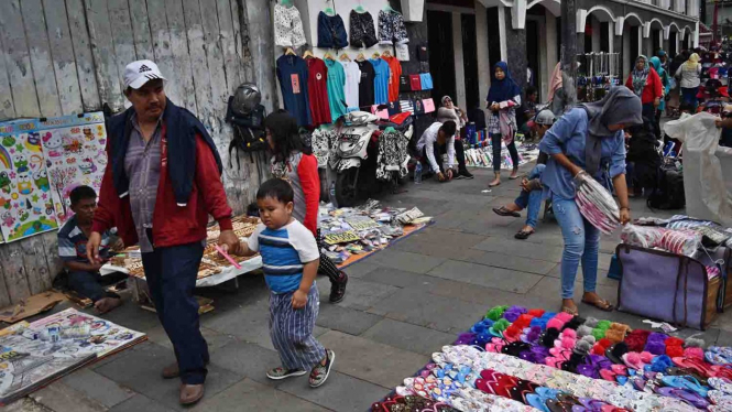 Warga berjalan di trotoar yang menjadi lokasi berjualan pedagang kaki lima (PKL) di kawasan Kota Tua, Jakarta, Sabtu, 20 April 2019.