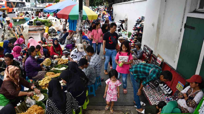 Warga berjalan di trotoar yang menjadi lokasi berjualan pedagang kaki lima (PKL) di kawasan Kota Tua, Jakarta, Sabtu, 20 April 2019.