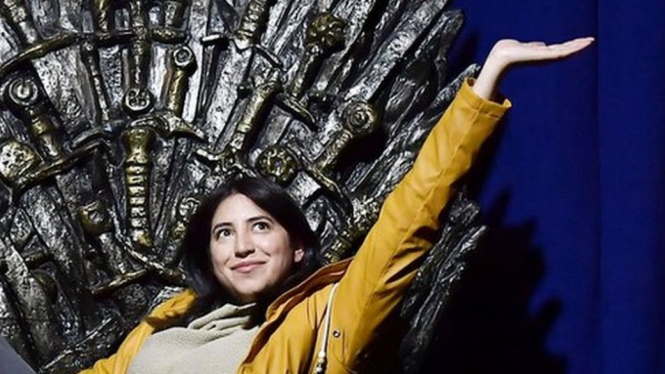 Penggemar di Belfast, Irlandia Utara, berpose di replika kursi tahta Game of Throne.-Getty Images